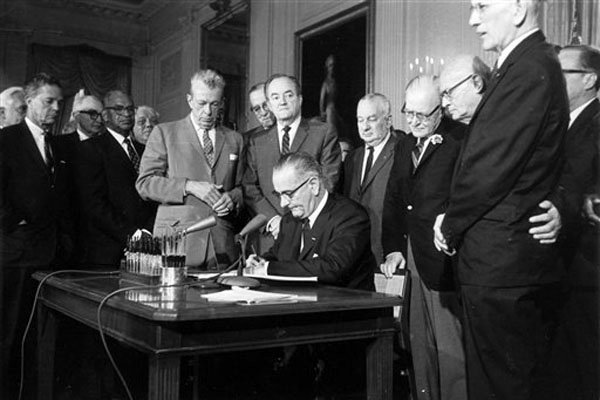 Lyndon Johnson signing equal right act based on gender. Image source